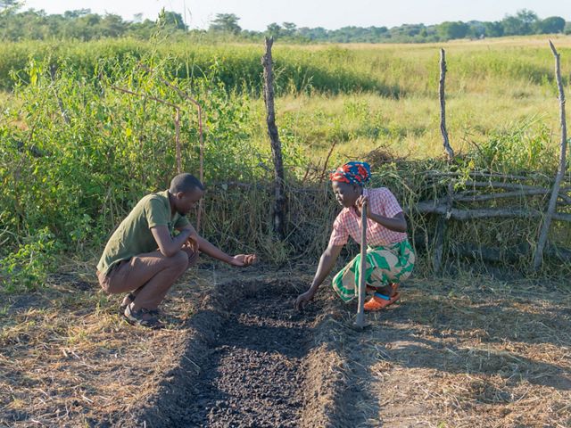 Charity Siankuku receives training on growing vegetables from TNC-supported agricultural extension officer Brian Chungu at her garden near Kapunda Village, Mulobezi, Zambia.